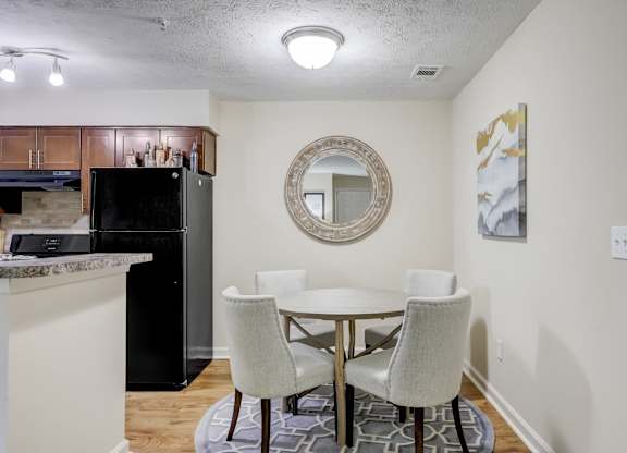 A kitchen with a table and chairs.