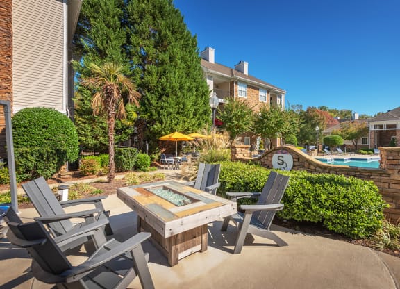 a patio with a table and chairs near a swimming pool