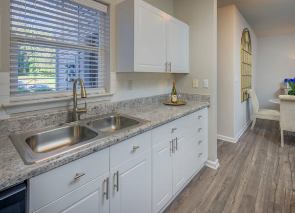 white kitchen cabinets and natural light filled kitchen with hardwood floors at Stone Ridge apartments Charlotte