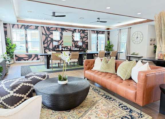 A living room with a brown leather couch and a round coffee table.