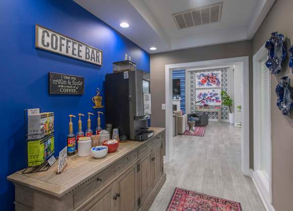 A coffee bar with a blue wall and a wooden counter.