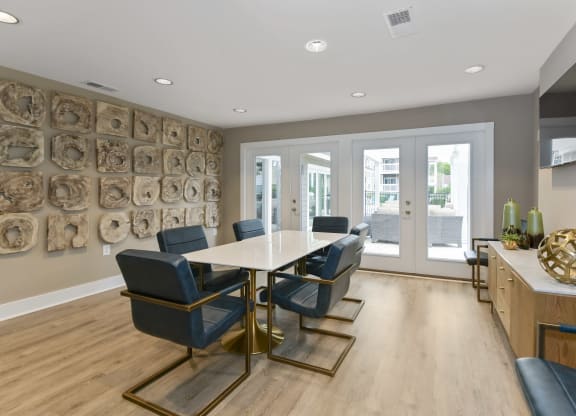 a modern room with a table and chairs and a television on the wall at Canopy apartments in South Charlotte