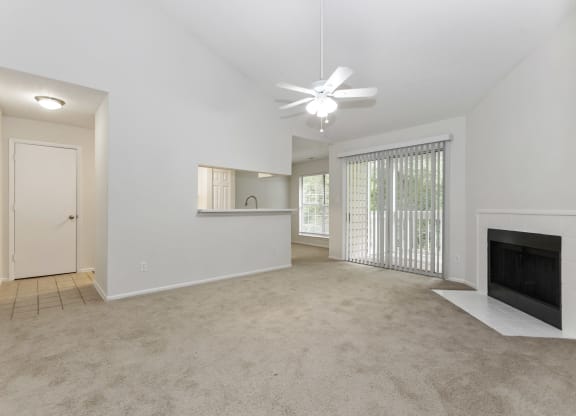 a living room with a fireplace and a ceiling fan at Canopy at Baybrook apartments in Charlotte NC
