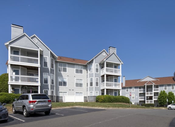 a large apartment complex with cars parked in front of it