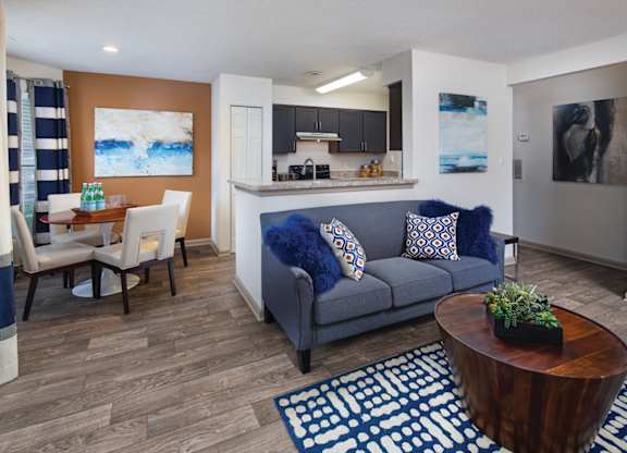 A living room with a blue couch and a wooden coffee table.