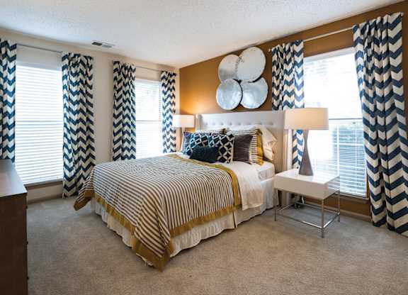A bedroom with a large bed and a chair.