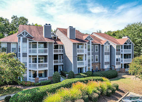 A large apartment complex with multiple balconies and a mix of brick and siding exteriors.