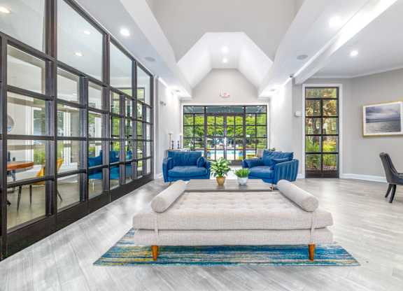 A modern living room with a large window and a view of the trees outside.