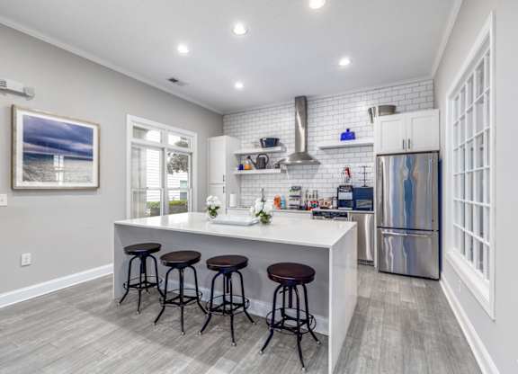 A kitchen with a white countertop and a refrigerator.
