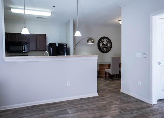 A kitchen with a white counter and a clock on the wall.