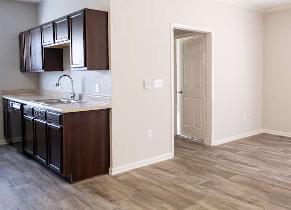 A kitchen with dark brown cabinets and a white sink.