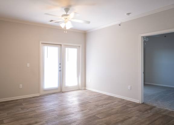 A room with a ceiling fan and two doors.