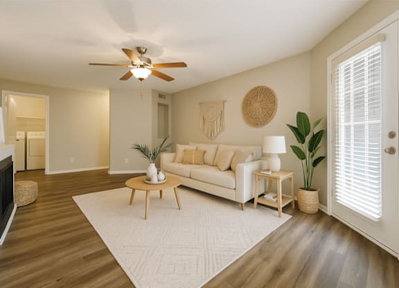 A living room with a white couch and a wooden coffee table.