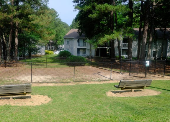 a park with two benches and a fence
