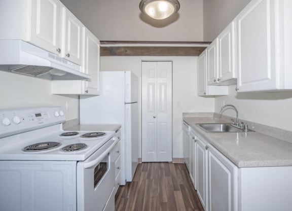 Renovated kitchen with white cabinets and all white appliances at Foster Creek apartments