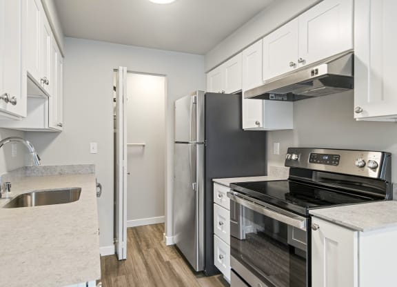 a kitchen with stainless steel appliances and white cabinets
