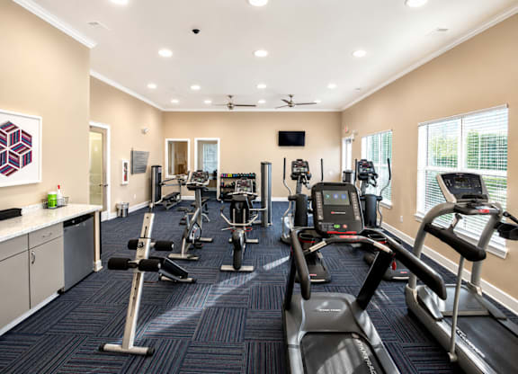 A gym with treadmills, elliptical machines, and other exercise equipment.