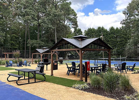 a picnic area with a pavilion next to a swimming pool