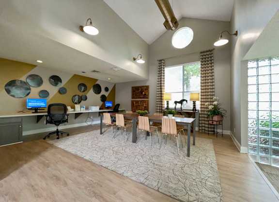 a large living room with a table and chairs and a window