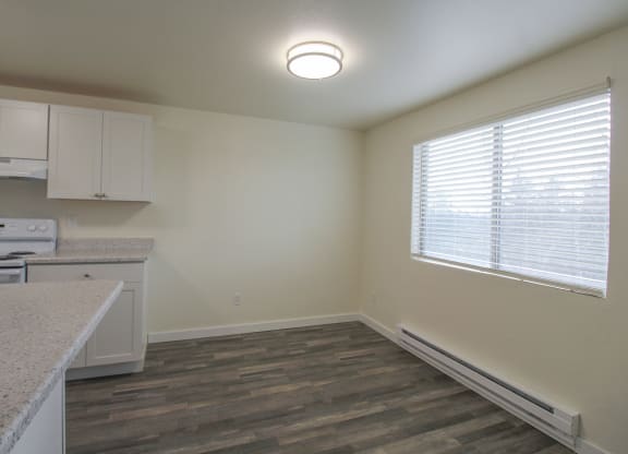1-Bedroom Apartments in Tacoma, WA - Valley Vista - Dining Area by the Kitchen with an Overhead Light, Wood-Style Flooring, and a Window