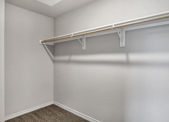 our spacious closets in our apartments have a large closet with a white wall and