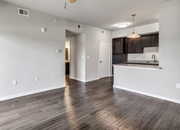 the living room and kitchen of an empty apartment