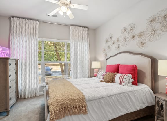 a bedroom with a large bed and a ceiling fan