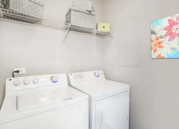 the washer dryer closet inside of an apartment at Seasons at Umstead apartments in Raleigh
