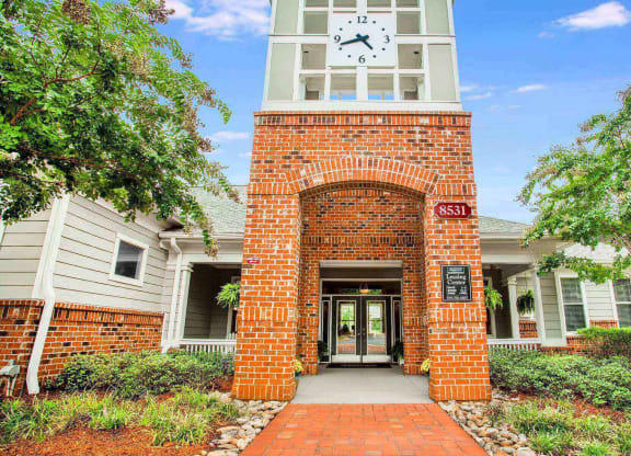 Entrance to leasing center at Seasons at Umstead apartments in Raleigh with clock tower and brick walls