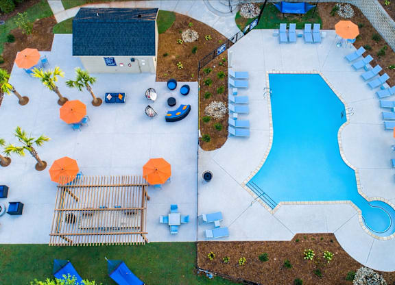 A pool with a slide and a deck with sun loungers.
