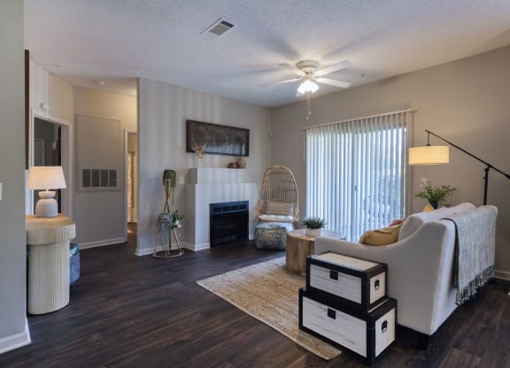 a living room at Seasons at Umstead apartments in Raleigh with a fireplace and a ceiling fan