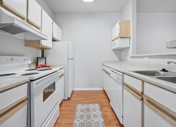 a kitchen with white cabinets and a wood floor