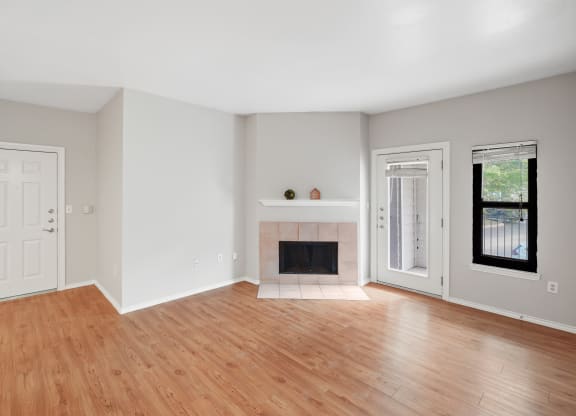 a bedroom with hardwood floors and a fireplace