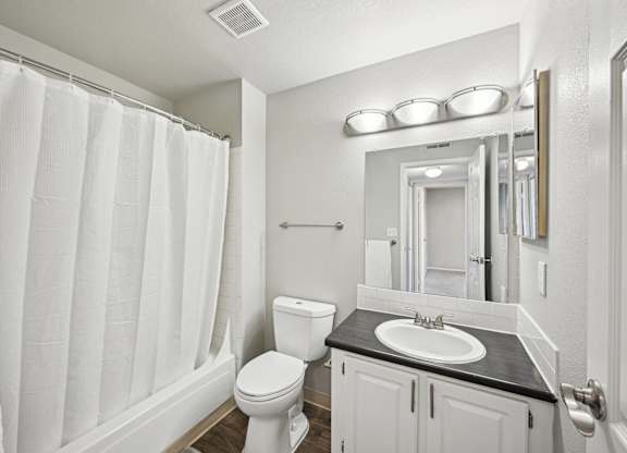 a white bathroom with a shower and a sink and a toilet