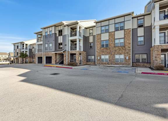 an empty parking lot in front of an apartment building
