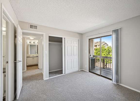 an empty living room with sliding glass doors to a balcony