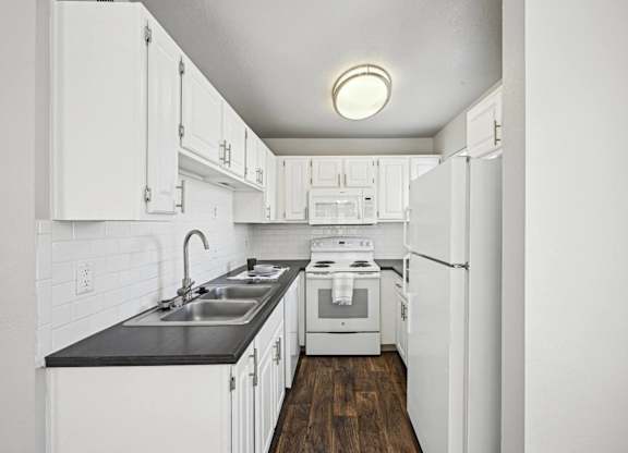 a white kitchen with white appliances and white cabinets