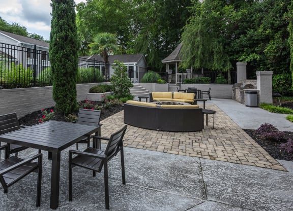 a patio with a table and chairs and a fire pit