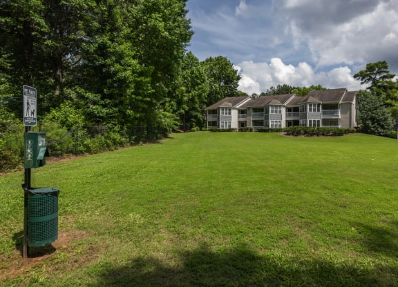 a green lawn in front of a house with a green mailbox