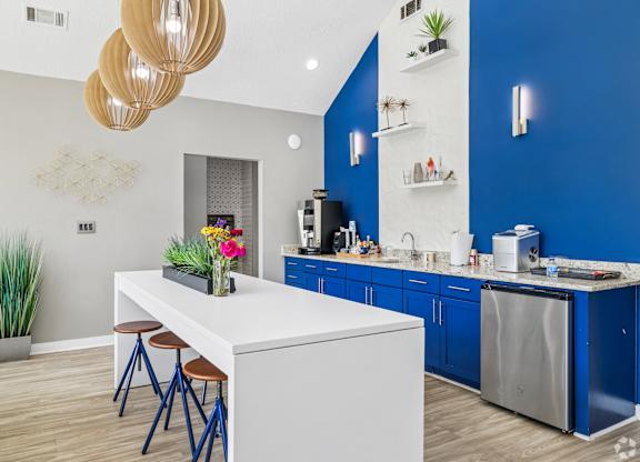 A kitchen with a white island and blue cabinets.