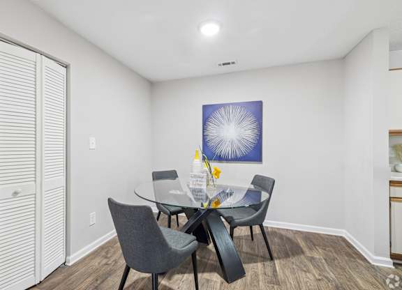 A dining room with a table and chairs.