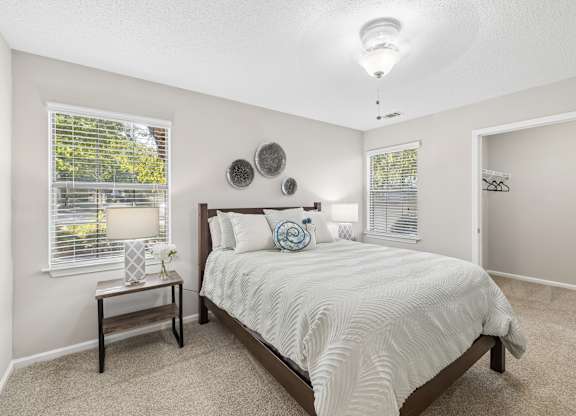 A bedroom with a bed, nightstand, and window.