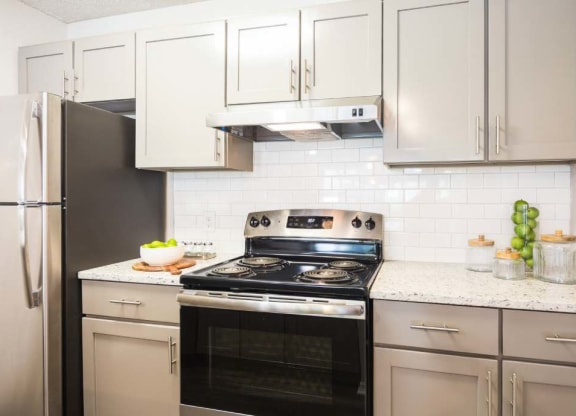 Renovated kitchen with stainless steel appliances and gray cabinets at Eclipse Apartments