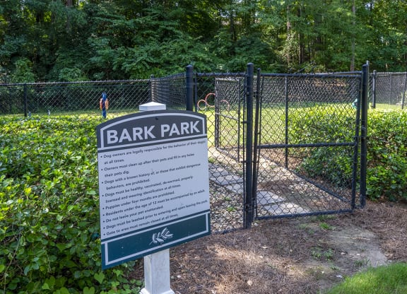 a sign for Wynnwood Vinings bark park in front of a fence