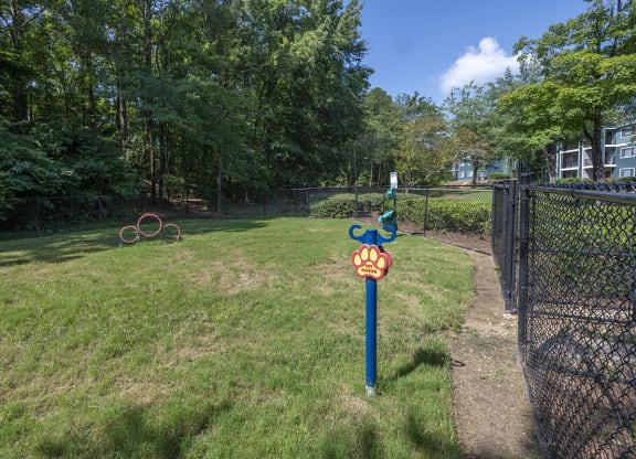 a post with a bark park sign in the middle of a fenced in off leash dog park at Wynnwood Vinings