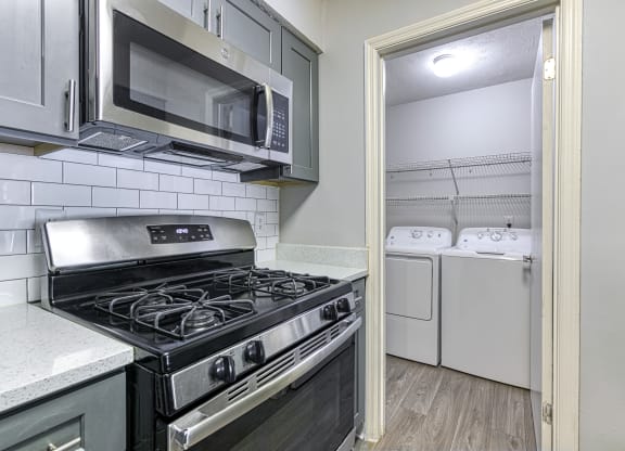 a kitchen view at Wynnwood Vinings with a stove and microwave and a washer and dryer