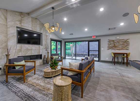 A living room with a flat screen TV mounted on a stone wall.