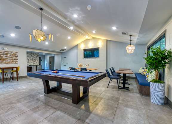 A room with a pool table and a tv mounted on the wall.
