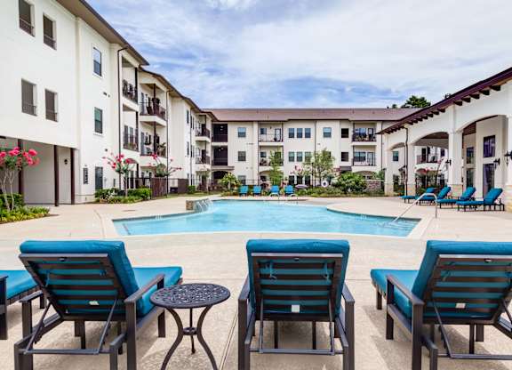 Pool along with chairs at The Laurel at Vintage Park 55+ Apartments, Tomball, 77377