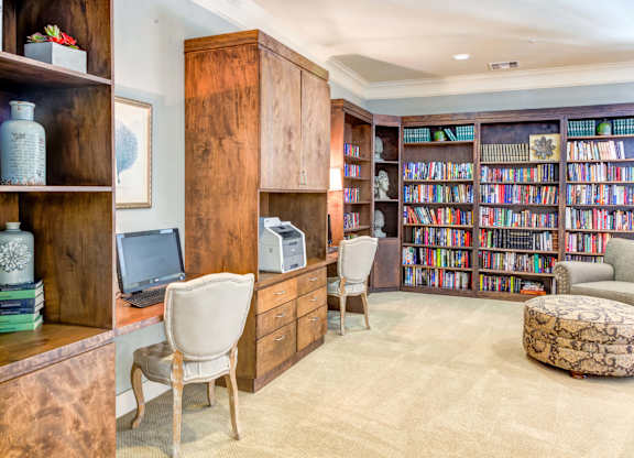 Wooden bookshelves, desks with computers, and comfortable seating areas at The Laurel at Vintage Park 55+ Apartments, Tomball Texas